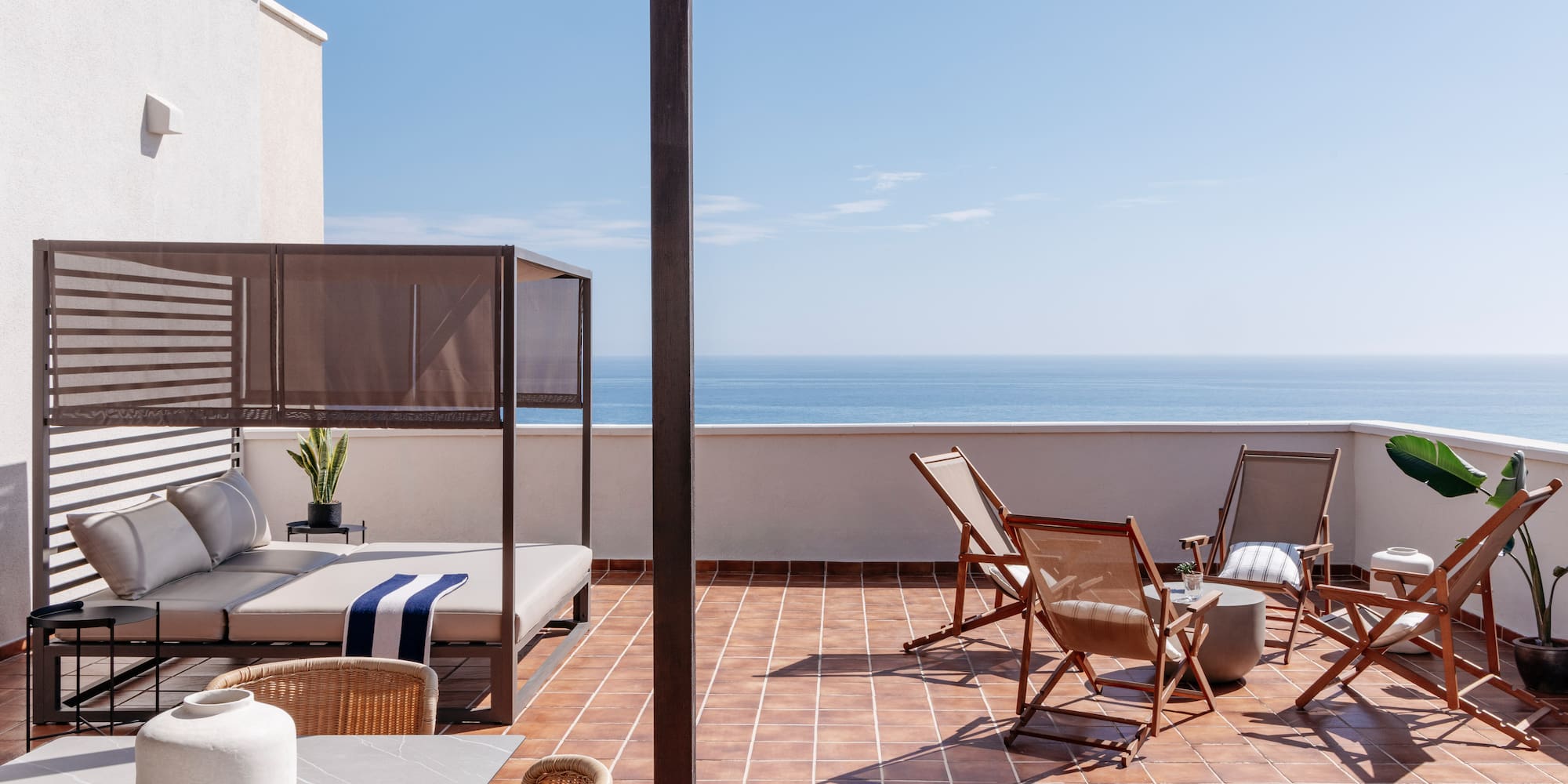 a patio with chairs and a table on a tile floor