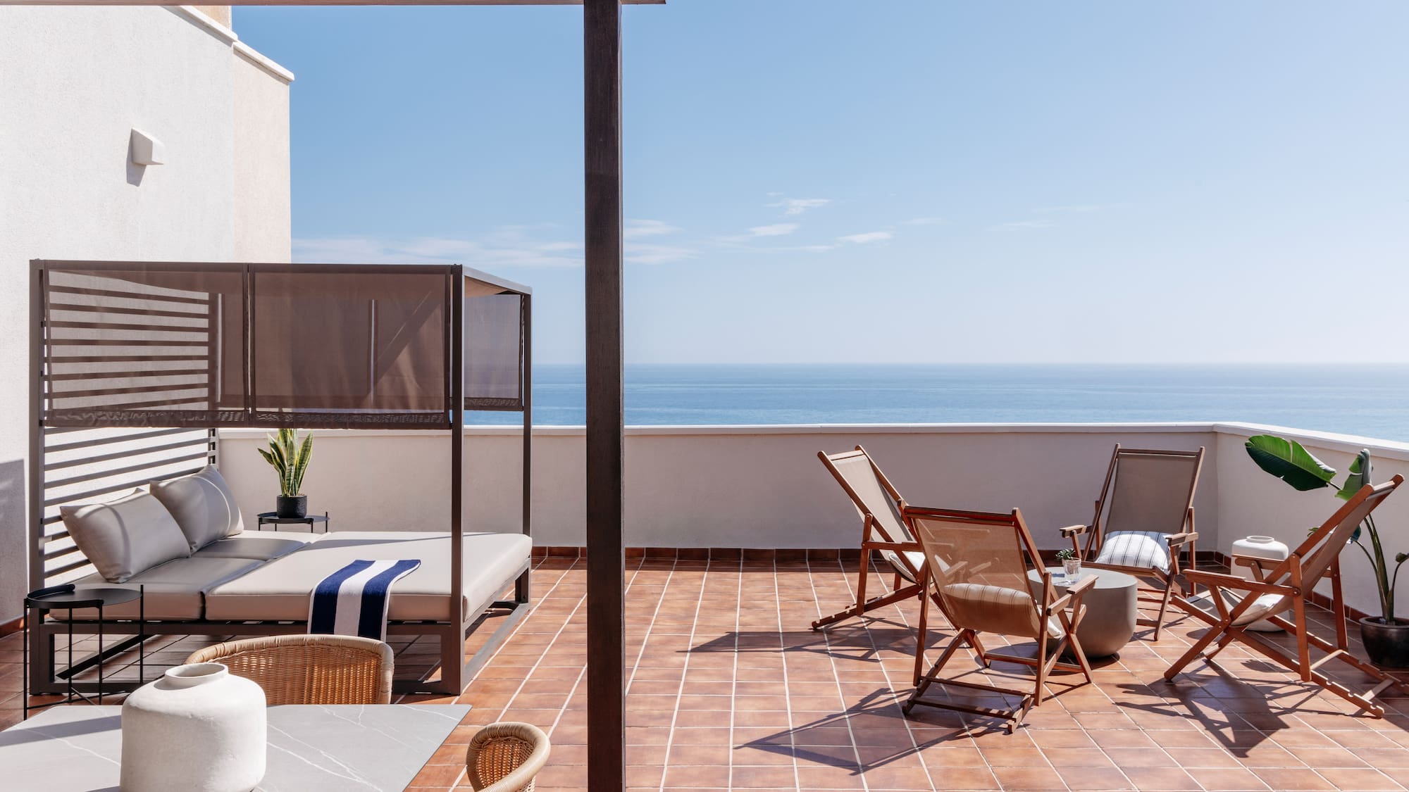 a patio with chairs and a table on a tile floor