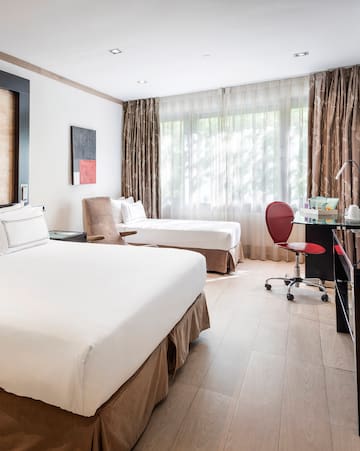 a room with two beds and a desk