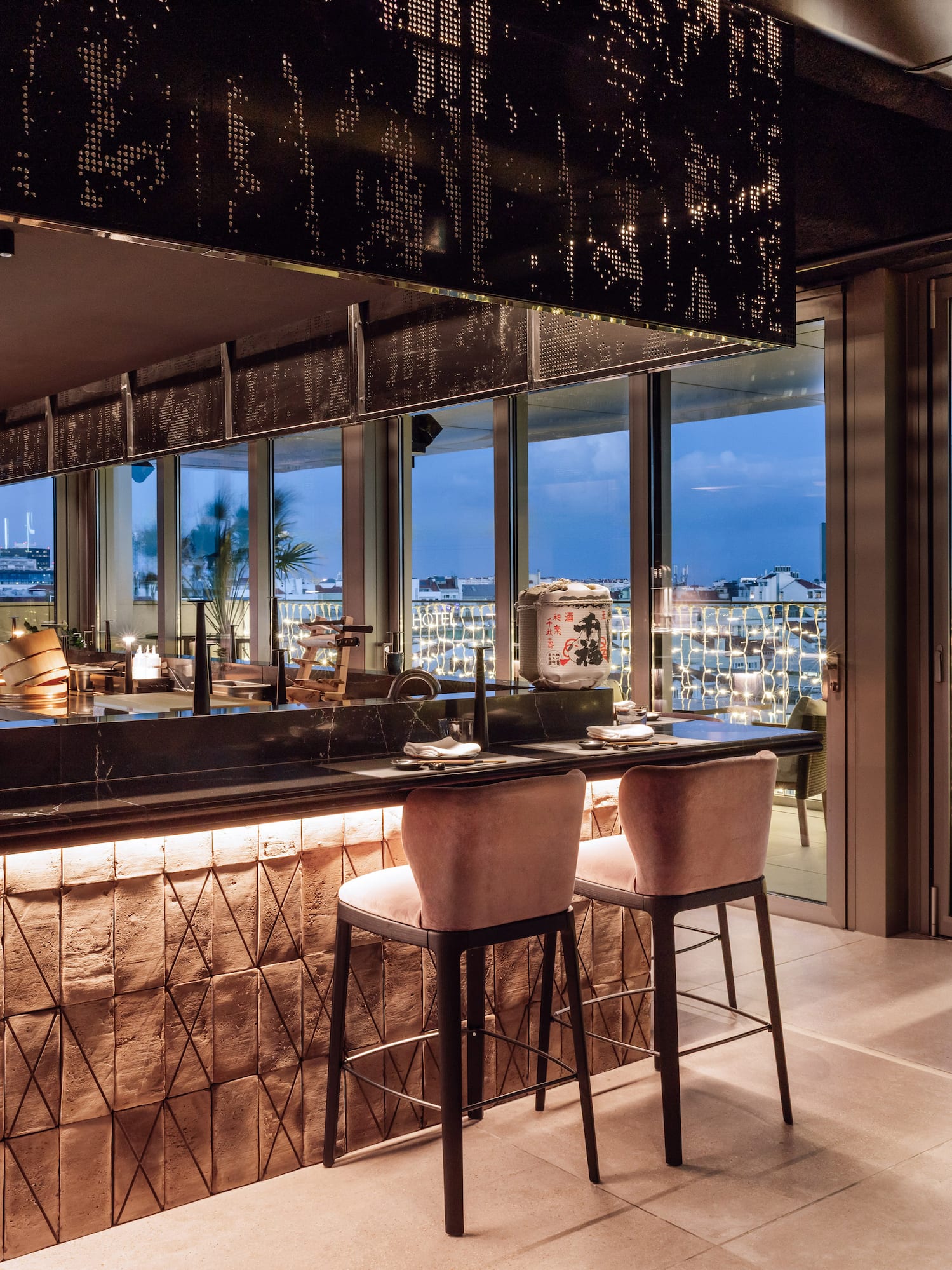 a bar with chairs and a view of the city from the window