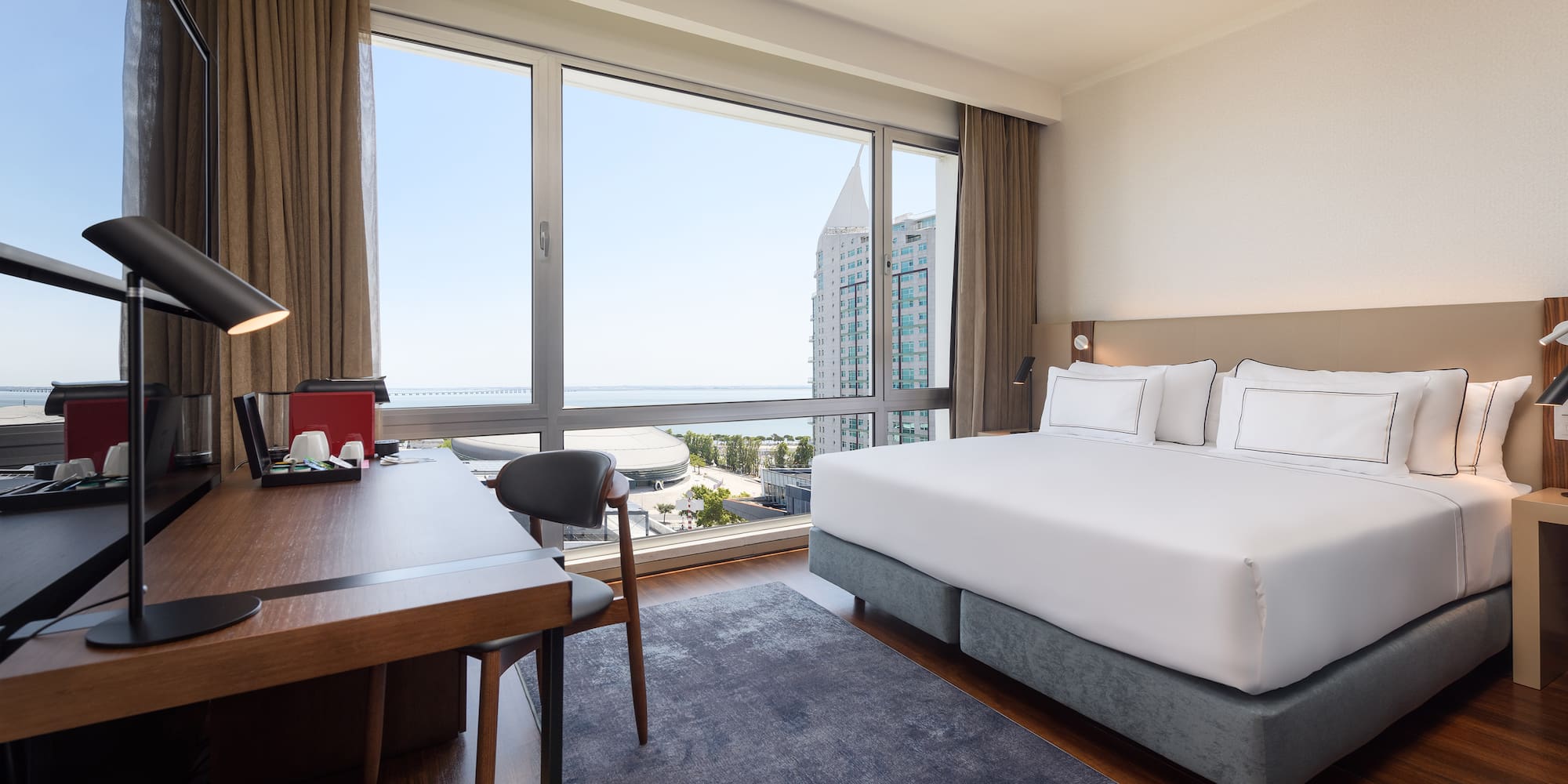 a room with a bed and a desk and a window