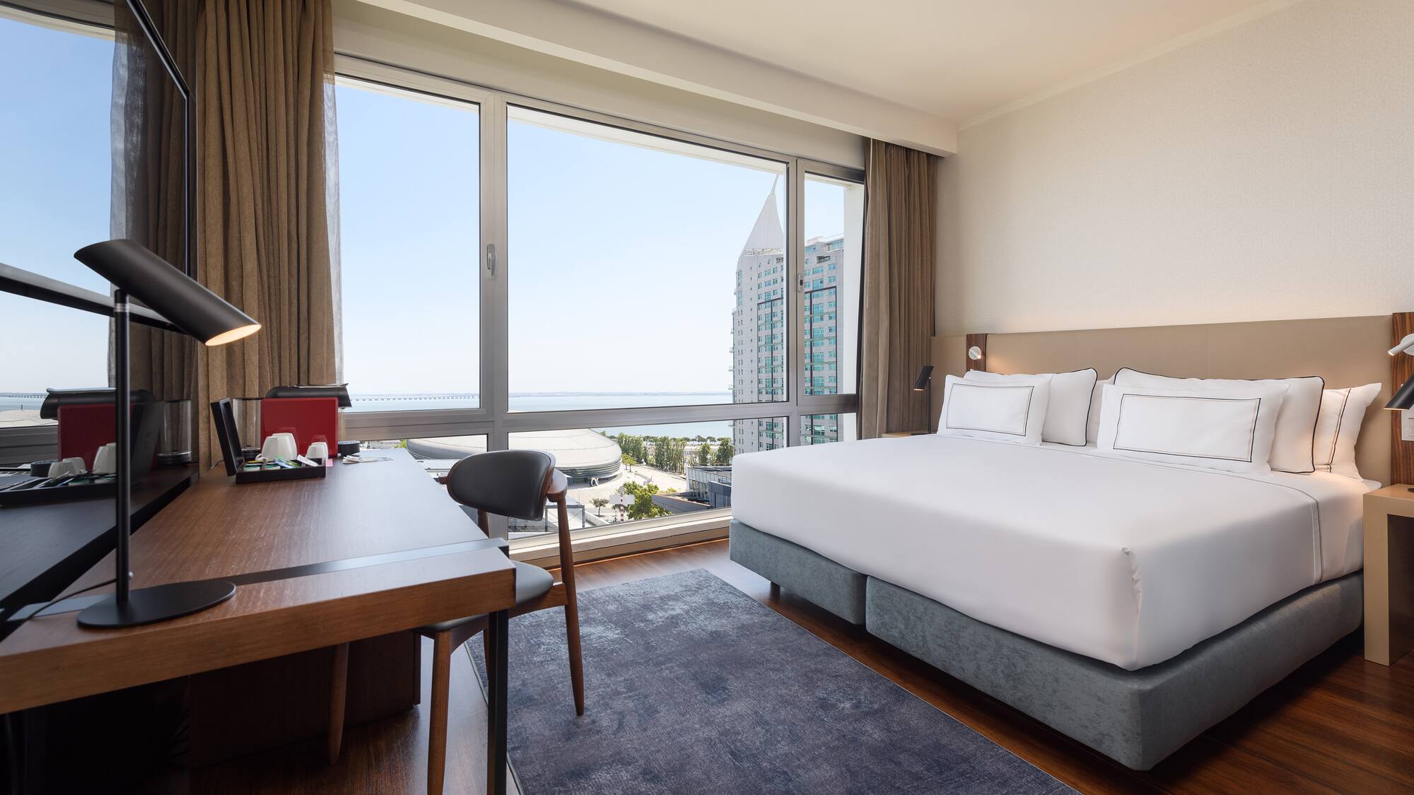 a room with a bed and a desk and a window