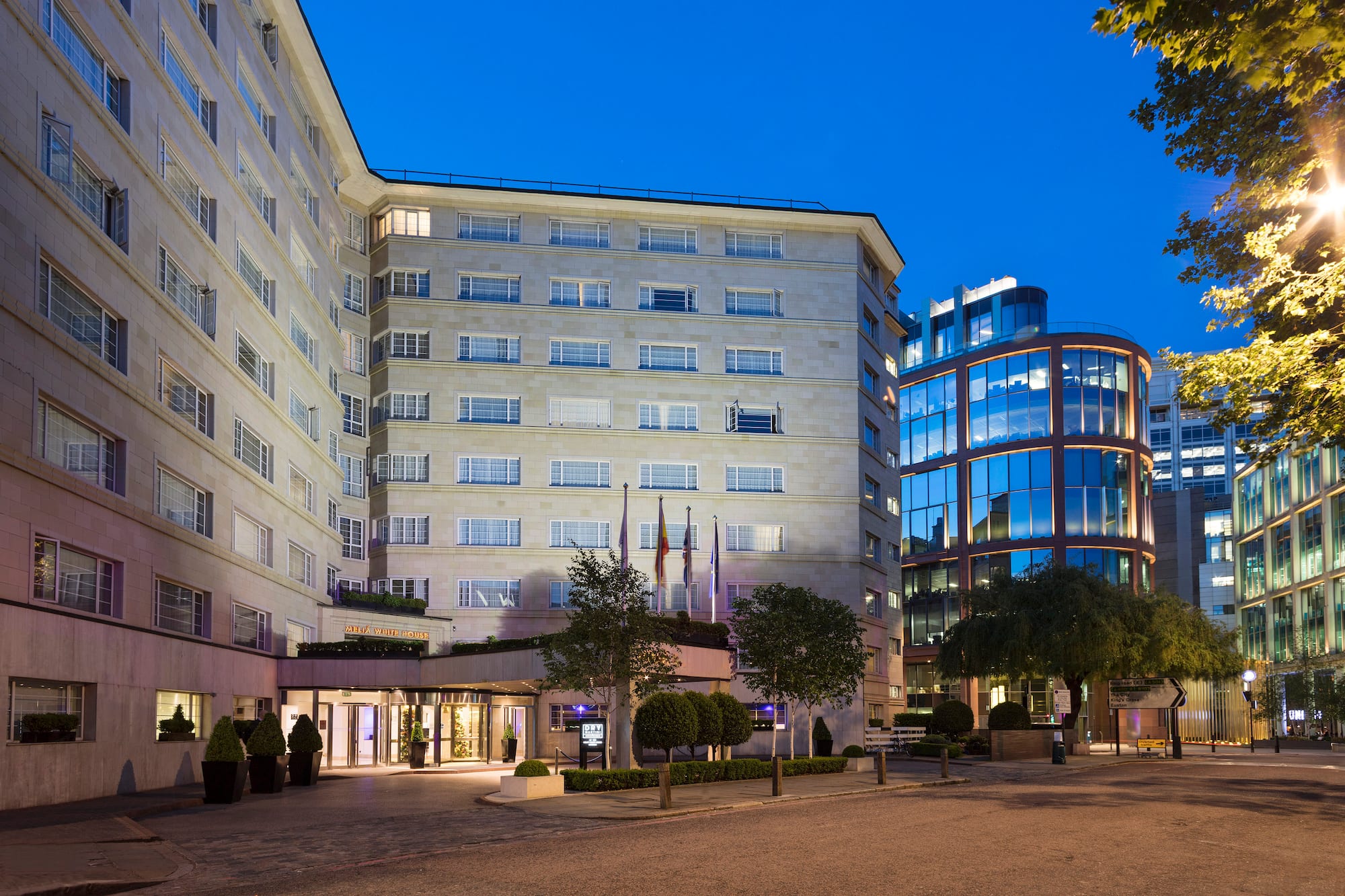 a building with a glass wall and trees