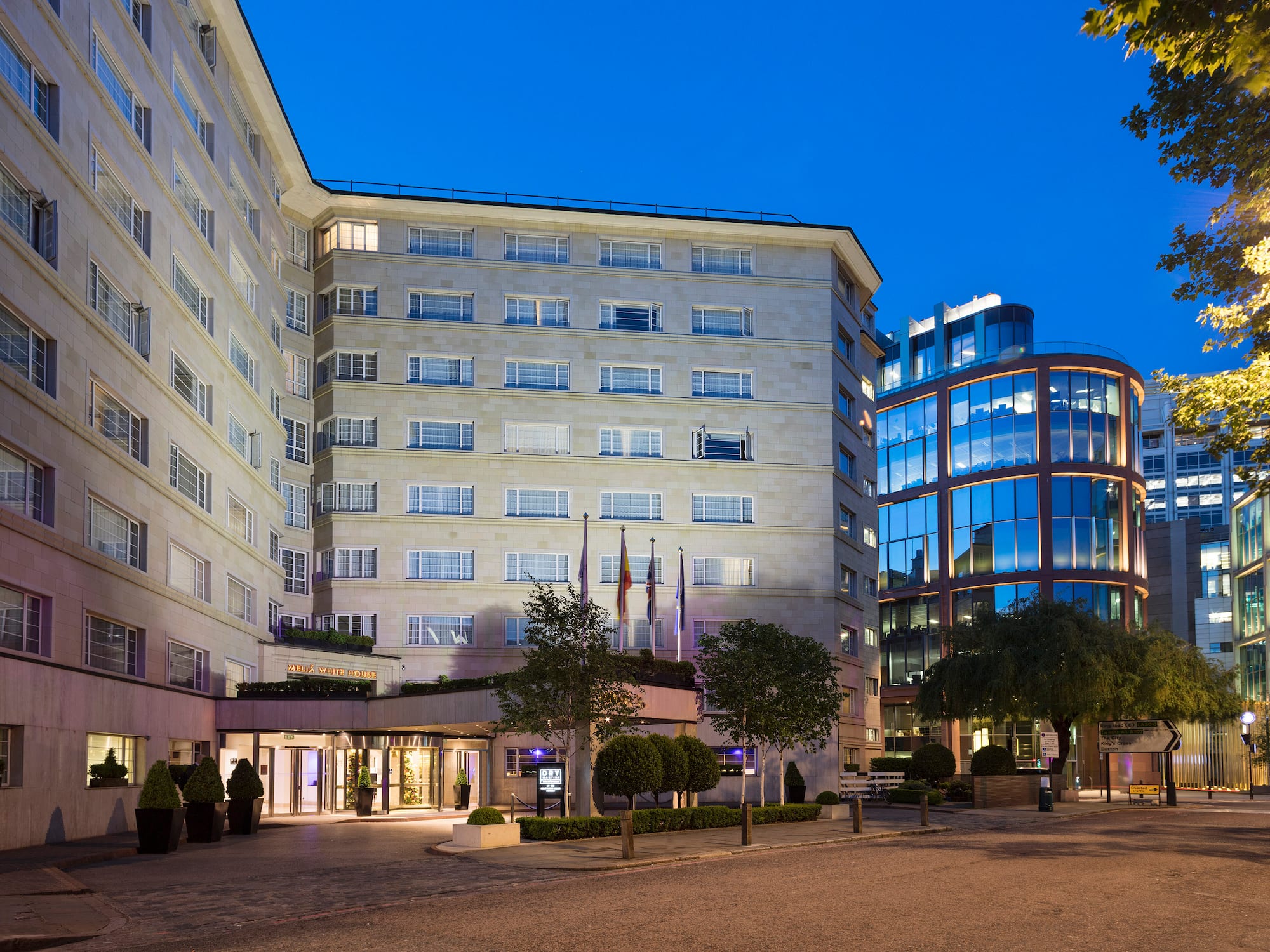 a building with a glass wall and trees