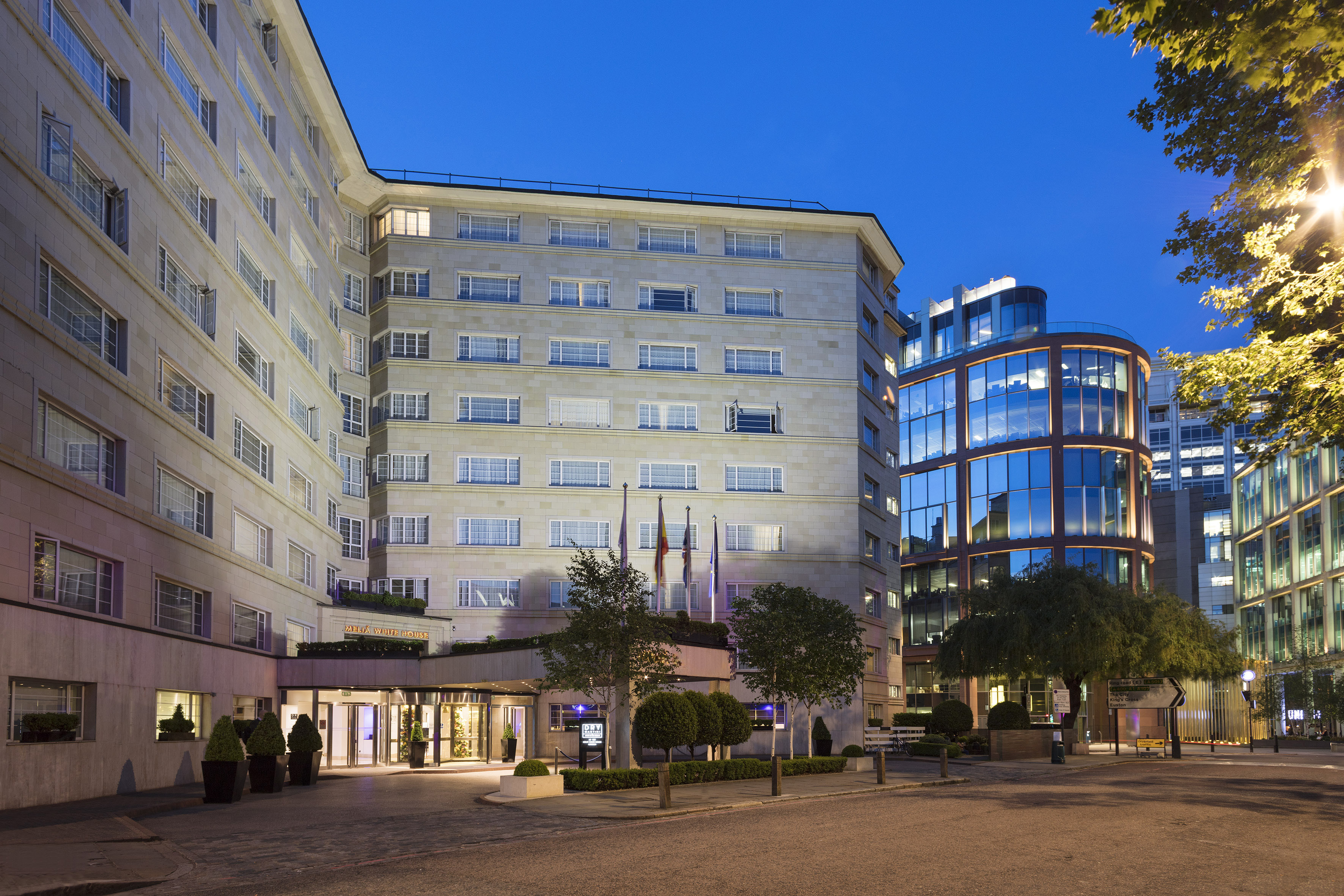 a building with a glass wall and trees
