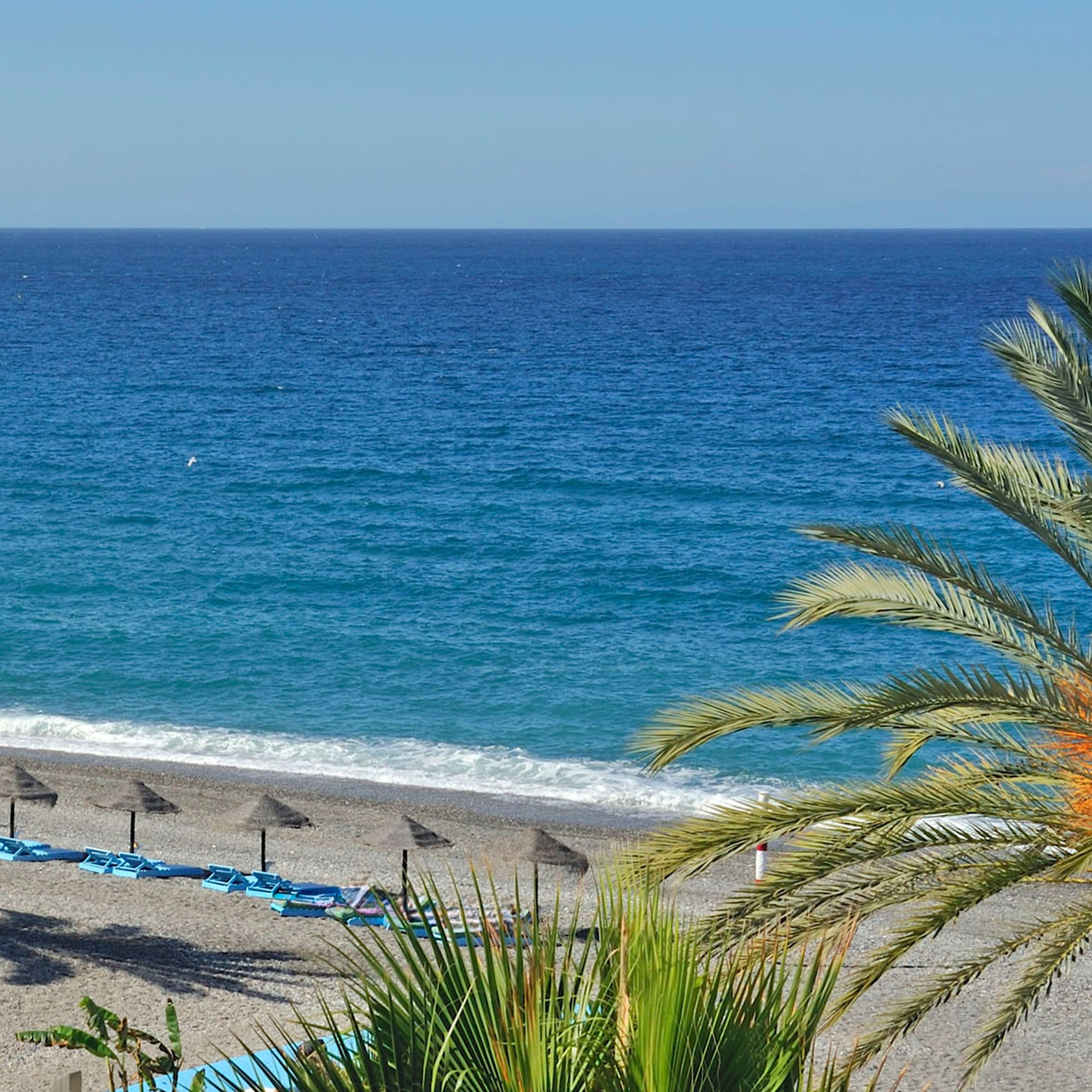 a beach with umbrellas and chairs