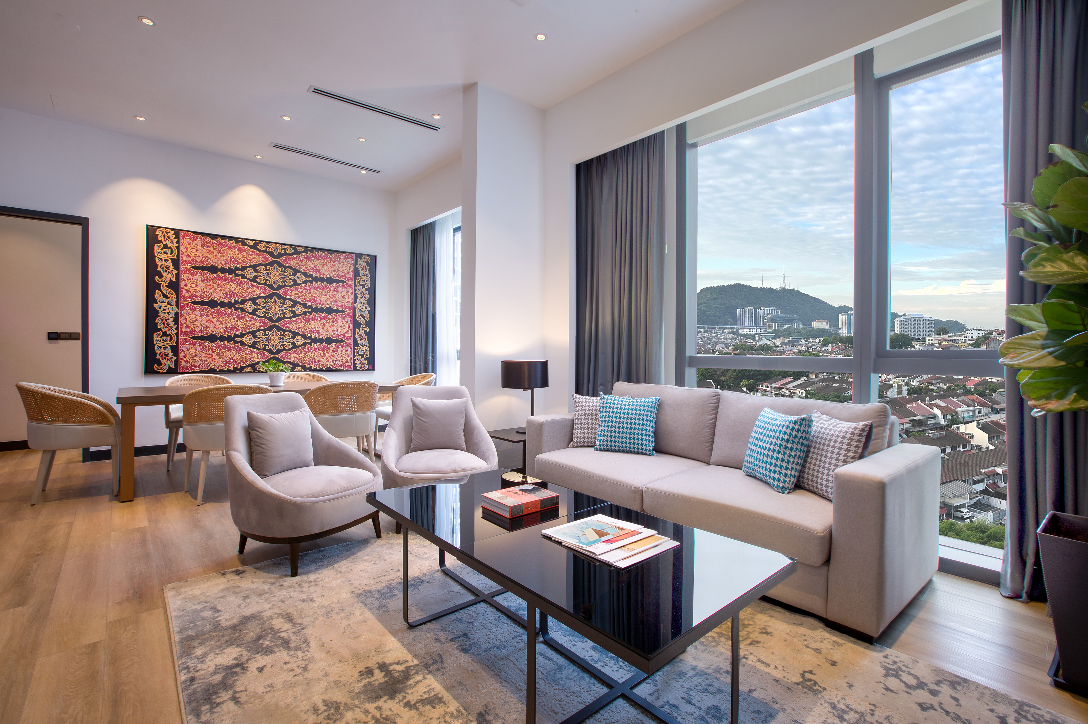 Modern luxury apartment living room with city view, dining area, and large tapestry.