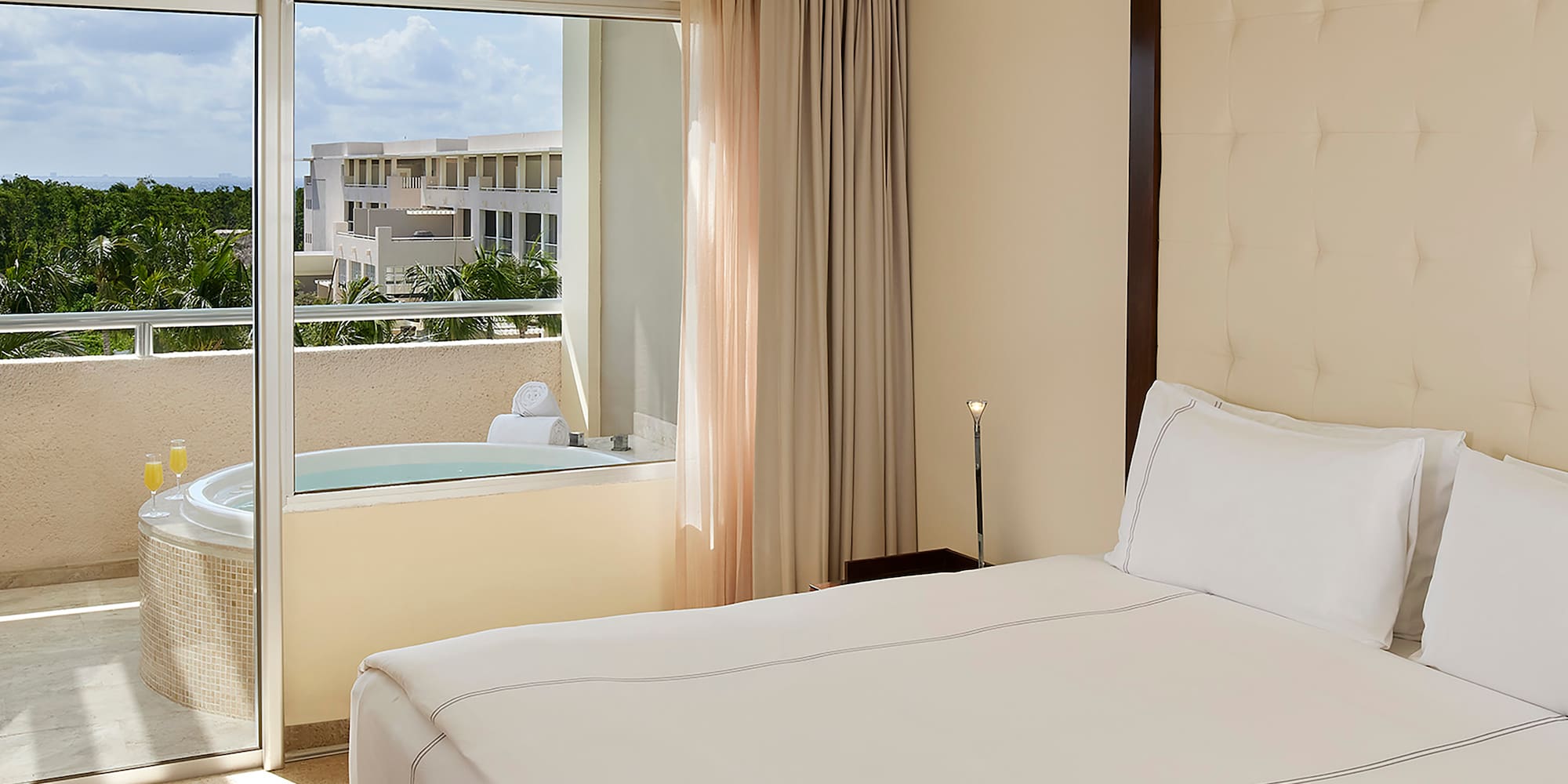 a bed with a glass door and a jacuzzi