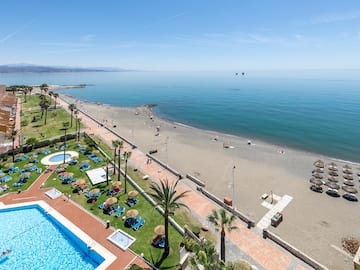 a beach with a pool and palm trees