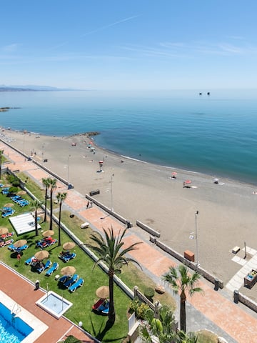 a beach with a pool and palm trees