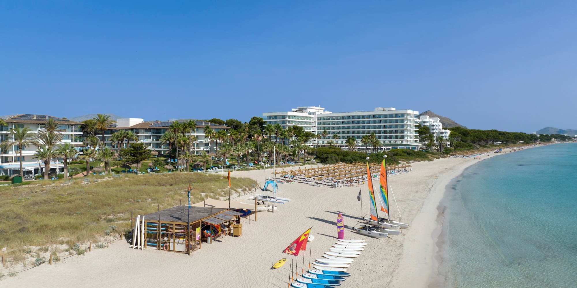 a beach with many chairs and umbrellas