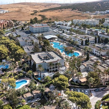a aerial view of a resort with swimming pools and trees