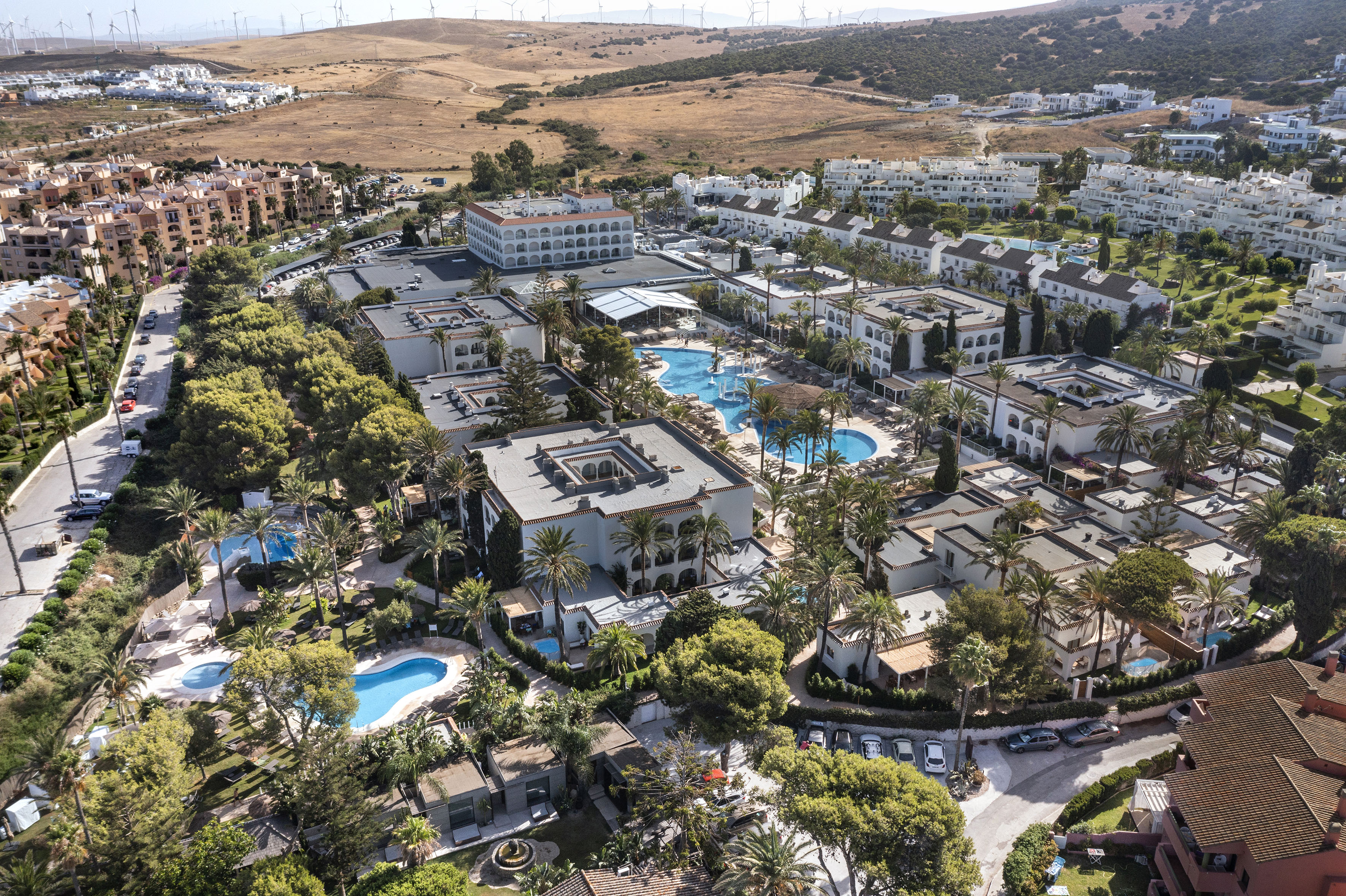 a aerial view of a resort with swimming pools and trees