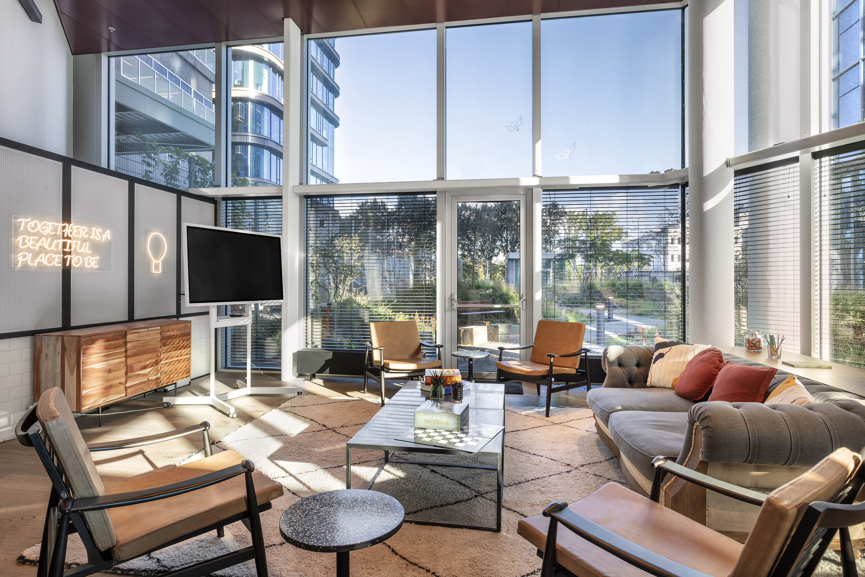 Stylish modern lounge with large windows, comfortable seating, and city view.