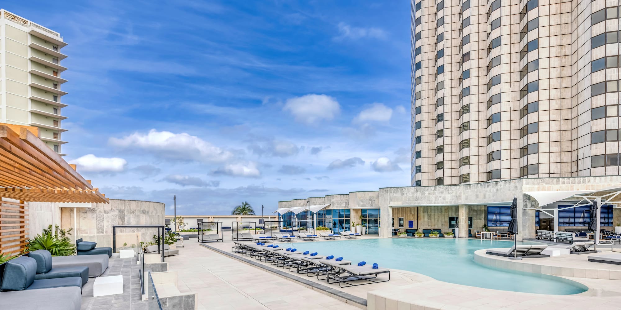 a pool with chairs and a building in the background