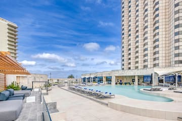 a pool with chairs and a building in the background