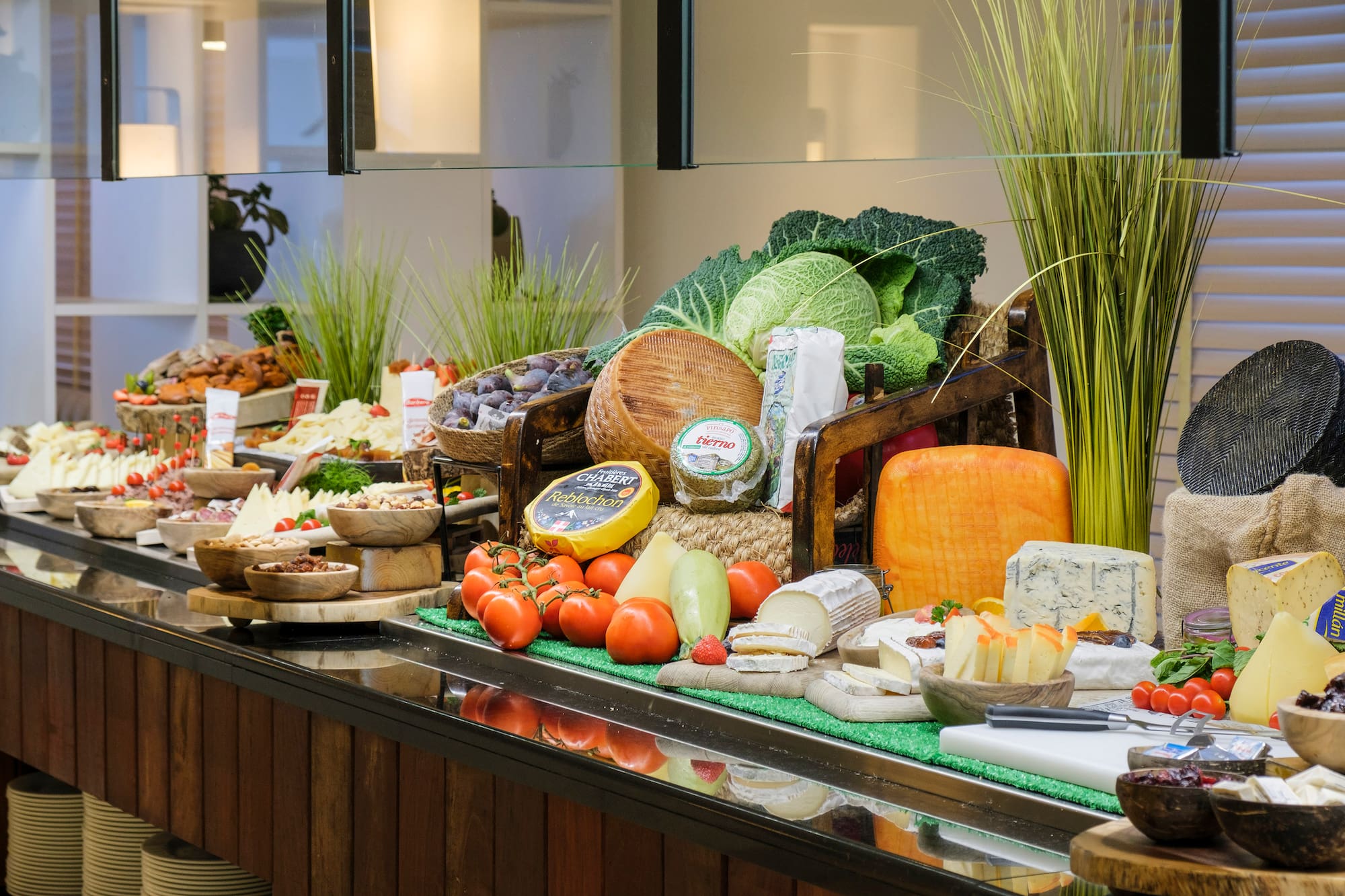 Gourmet cheese buffet featuring various cheeses, fresh fruits, and vegetables.
