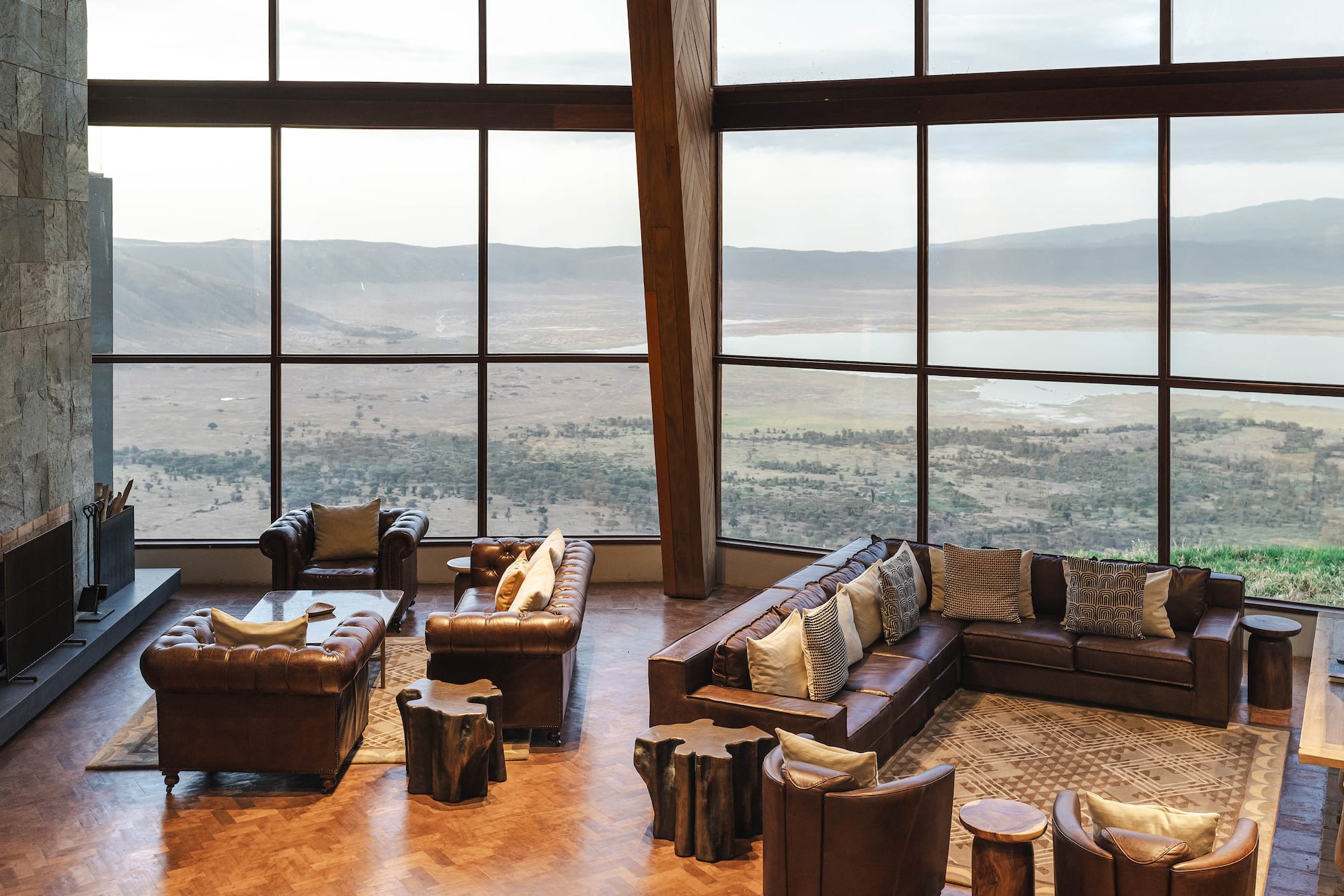 Luxury lodge lounge, leather seating, panoramic crater lake view.