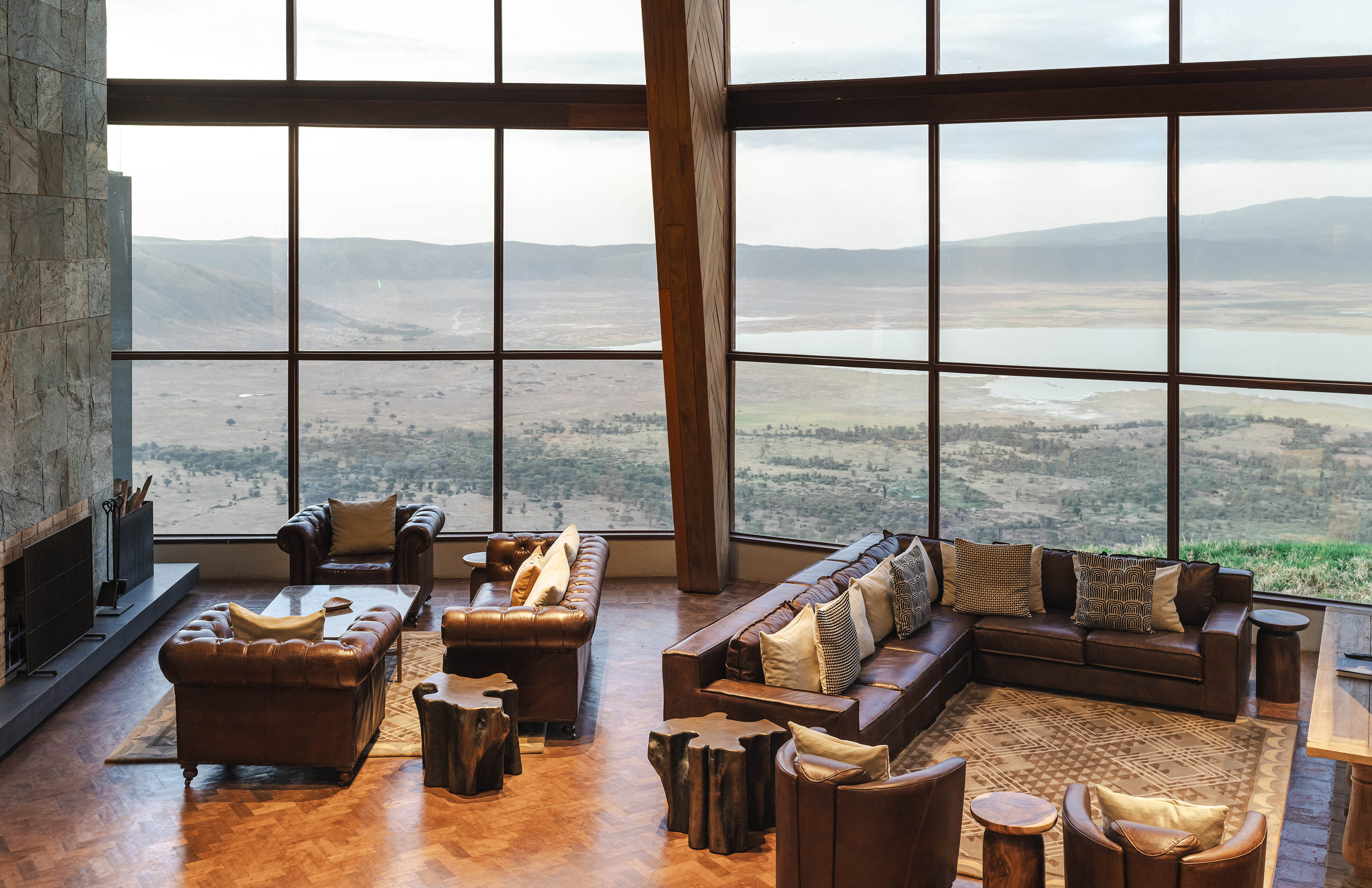Luxury lodge lounge, leather seating, panoramic crater lake view.