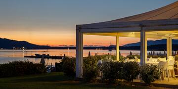 a white structure with a view of a body of water and a sunset