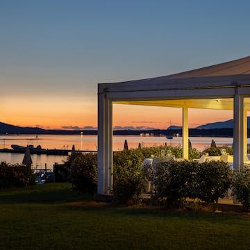 a white structure with a view of a body of water and a sunset