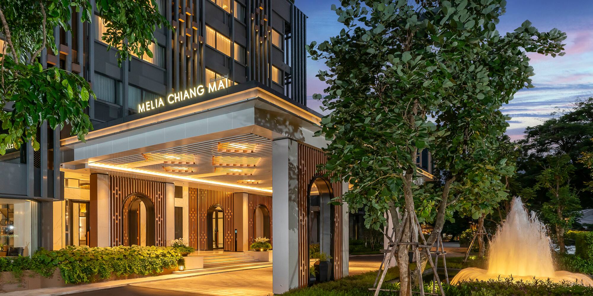 a building with a fountain and trees