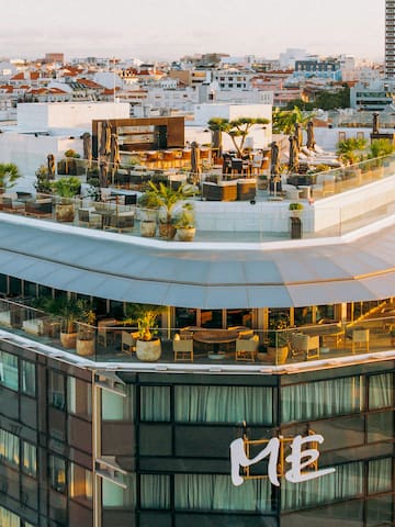a rooftop of a building with a rooftop bar and a city