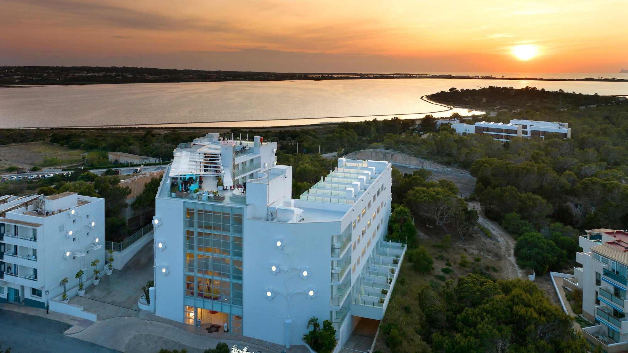 a building with trees and a body of water in the background