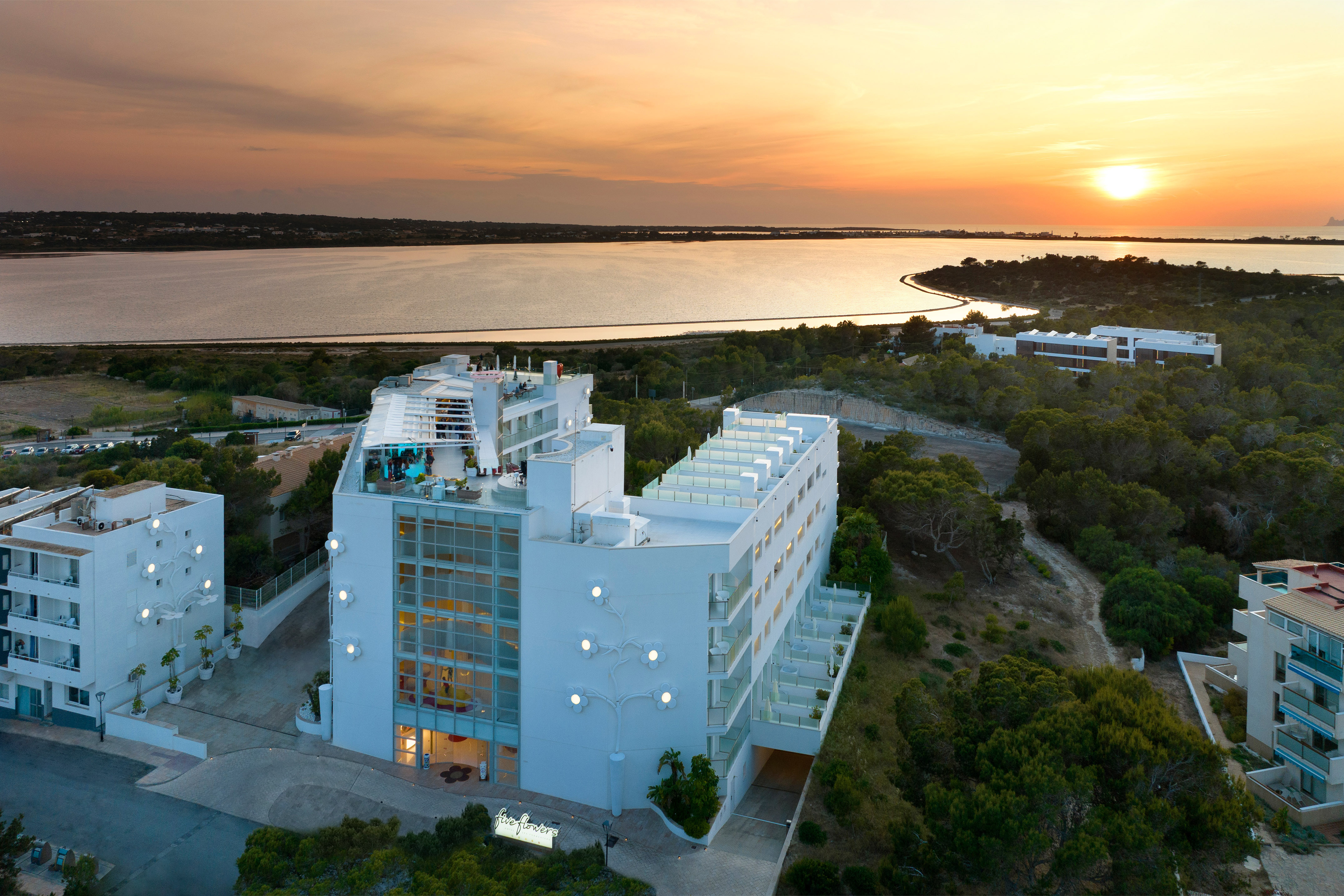 a building with trees and a body of water in the background