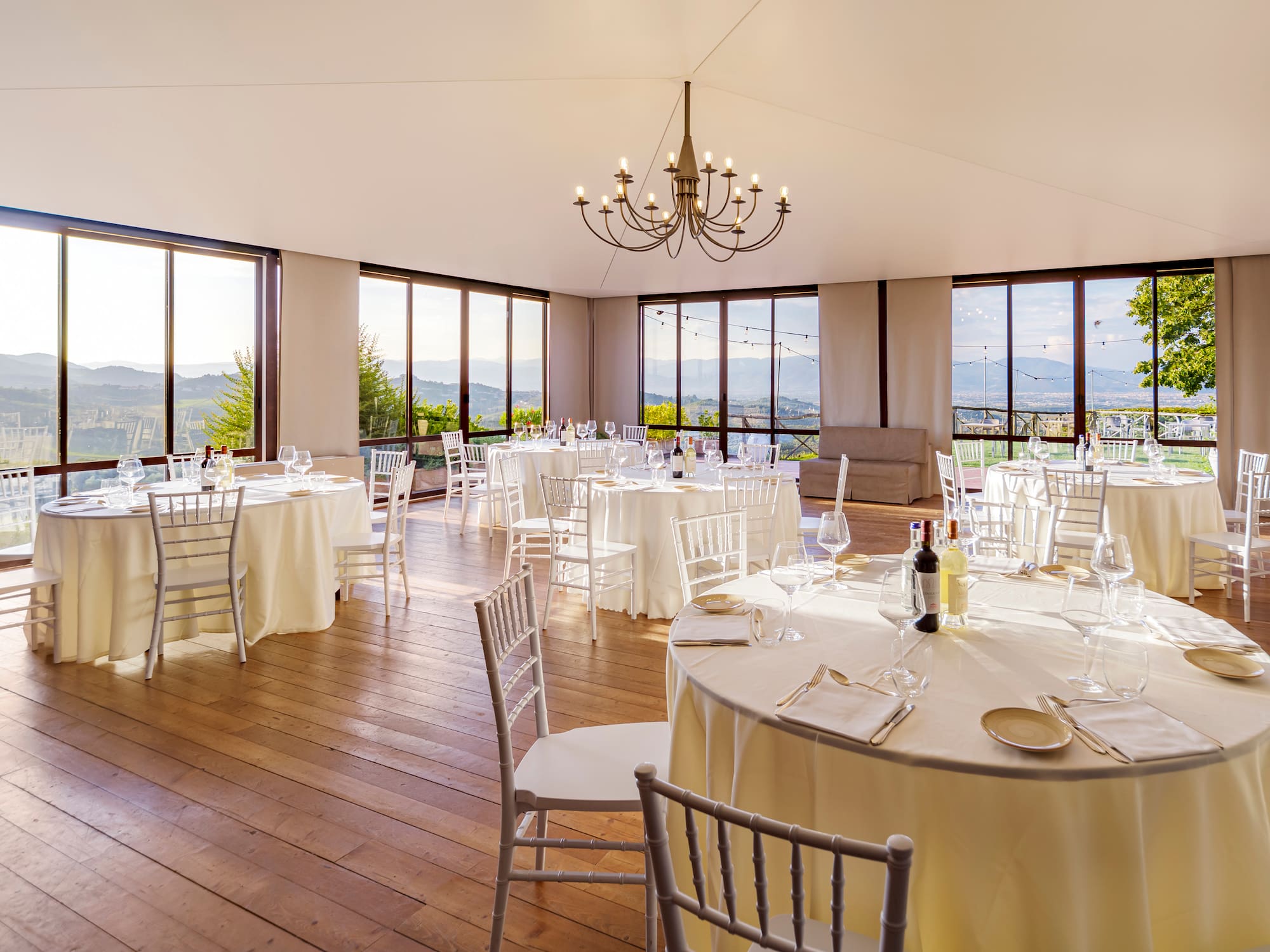 a room with tables and chairs and a chandelier