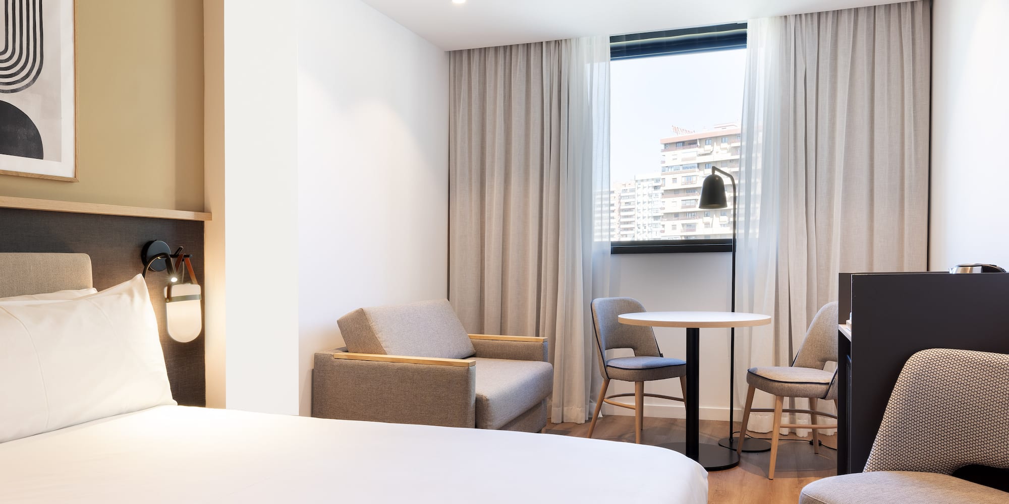 a room with a bed and chairs