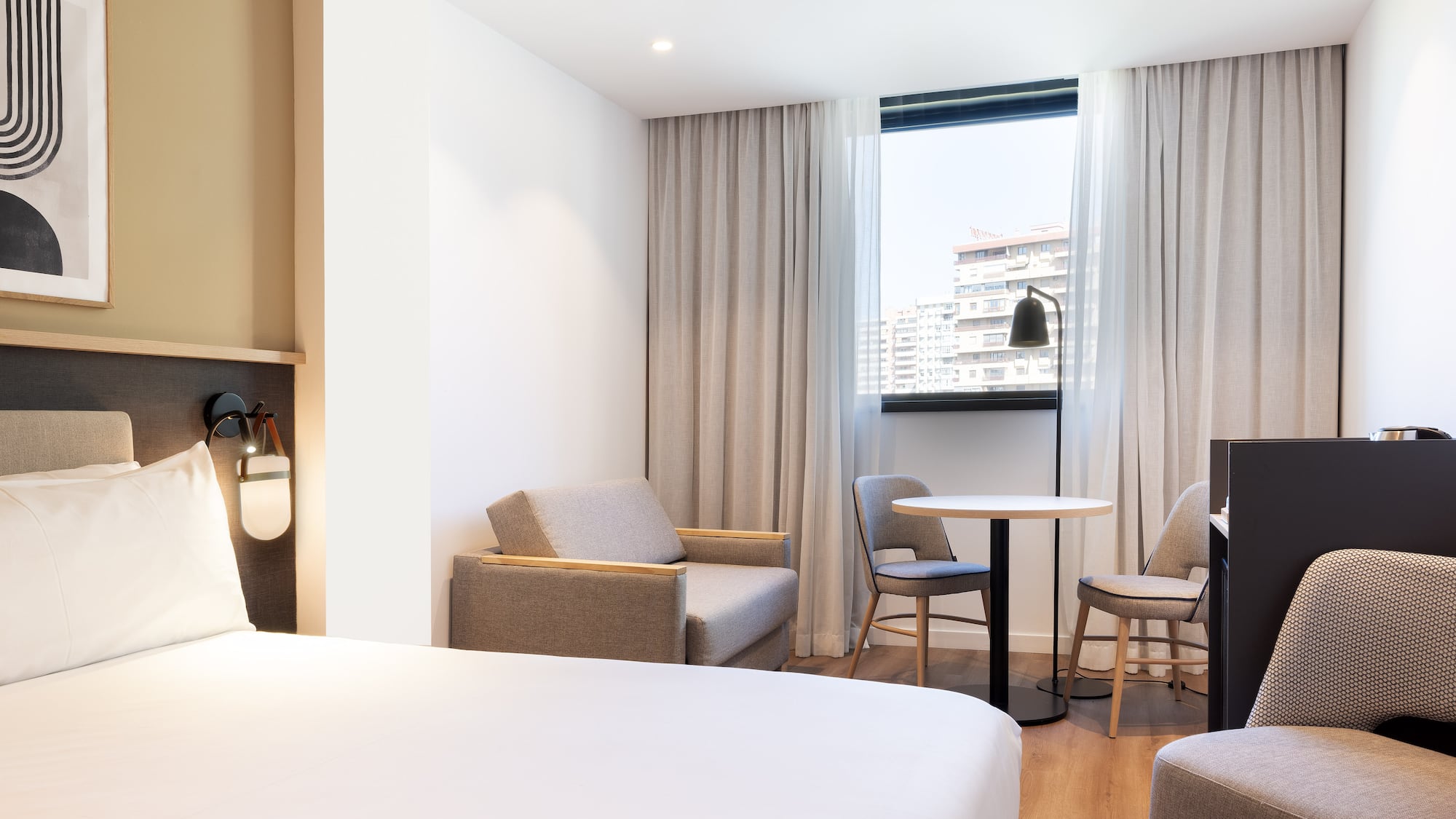 a room with a bed and chairs