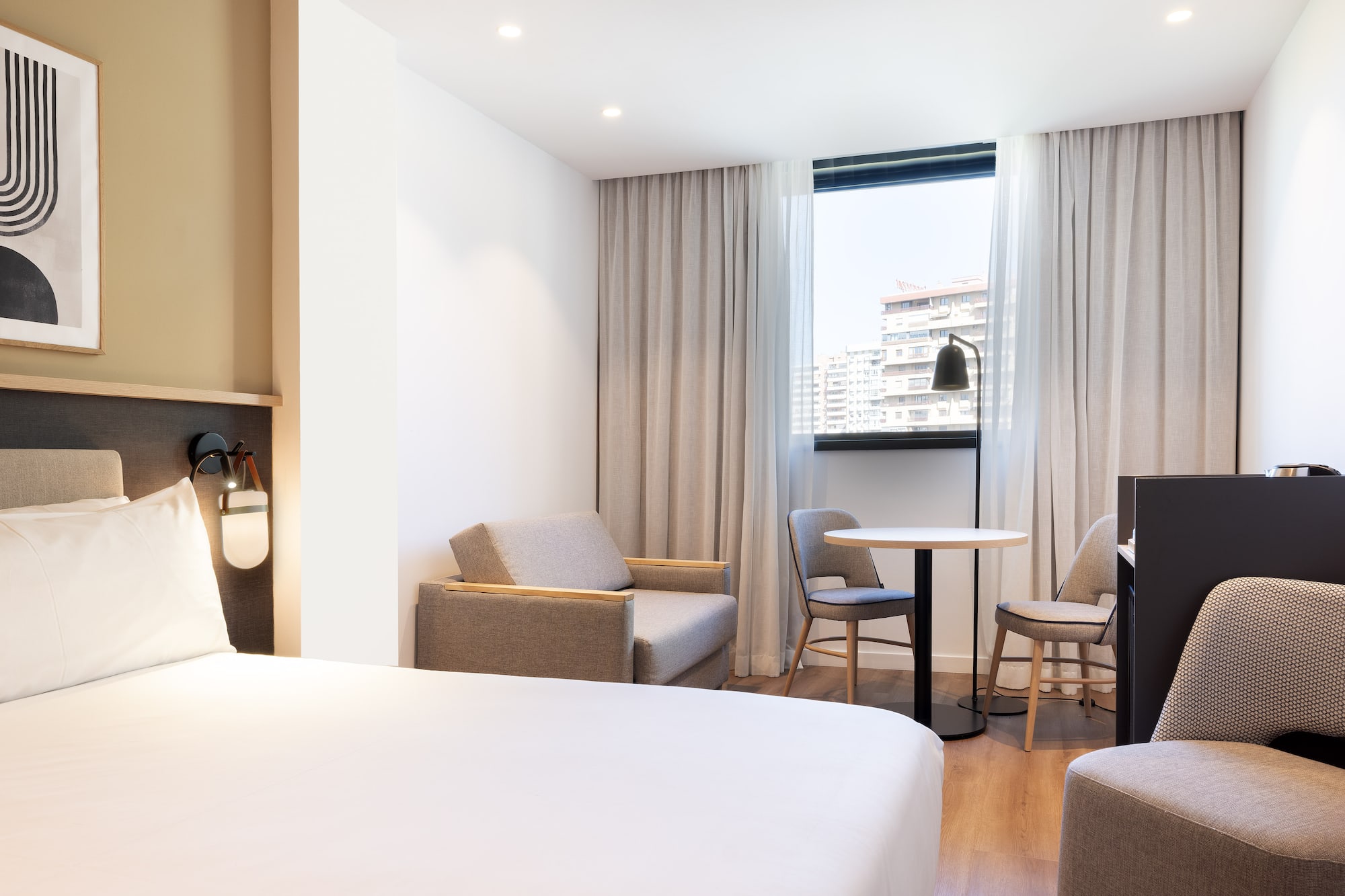 a room with a bed and chairs