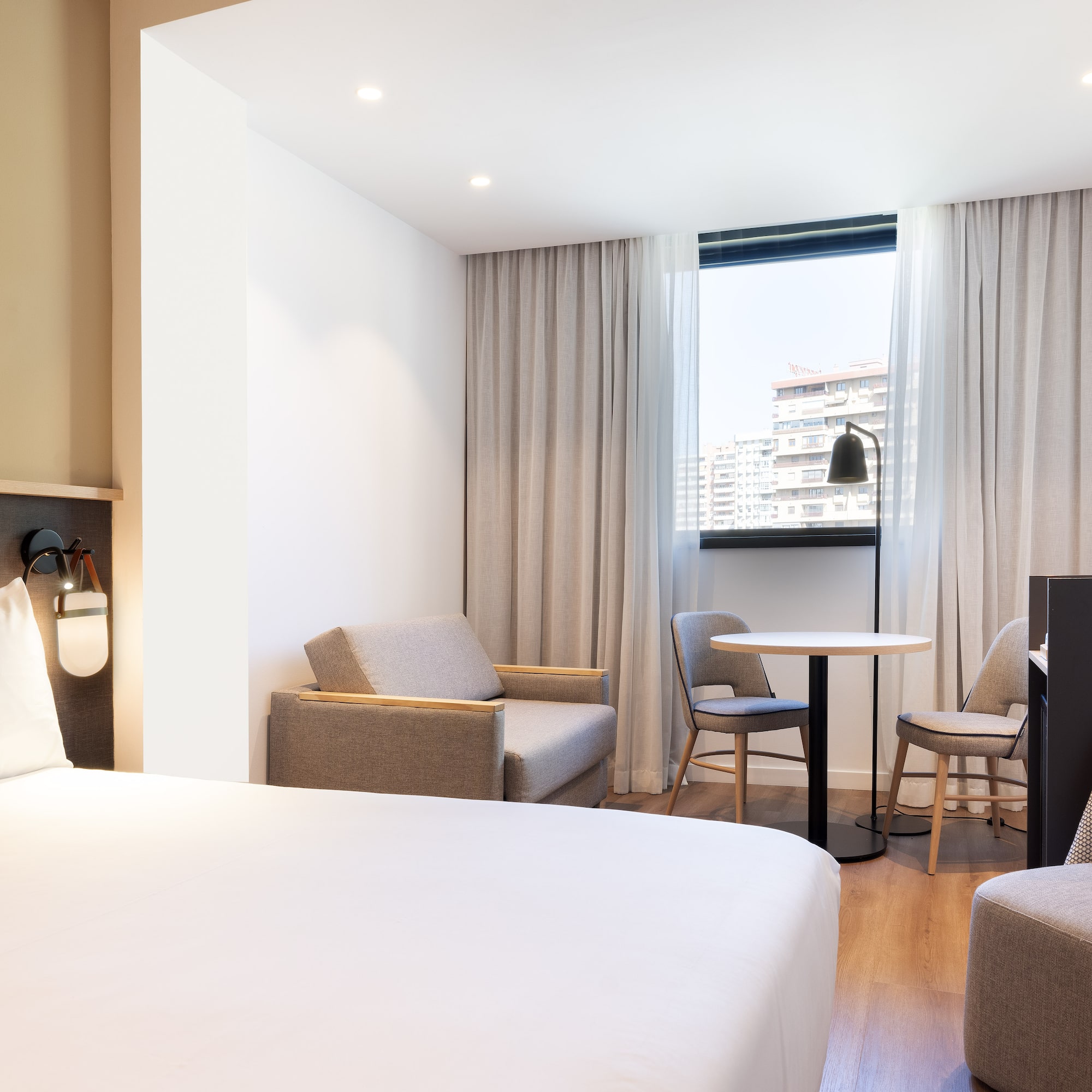 a room with a bed and chairs