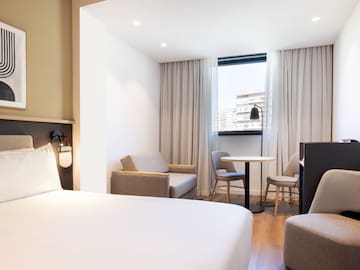 a room with a bed and chairs