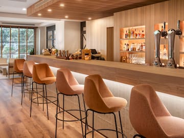 a bar with chairs and a beer dispenser