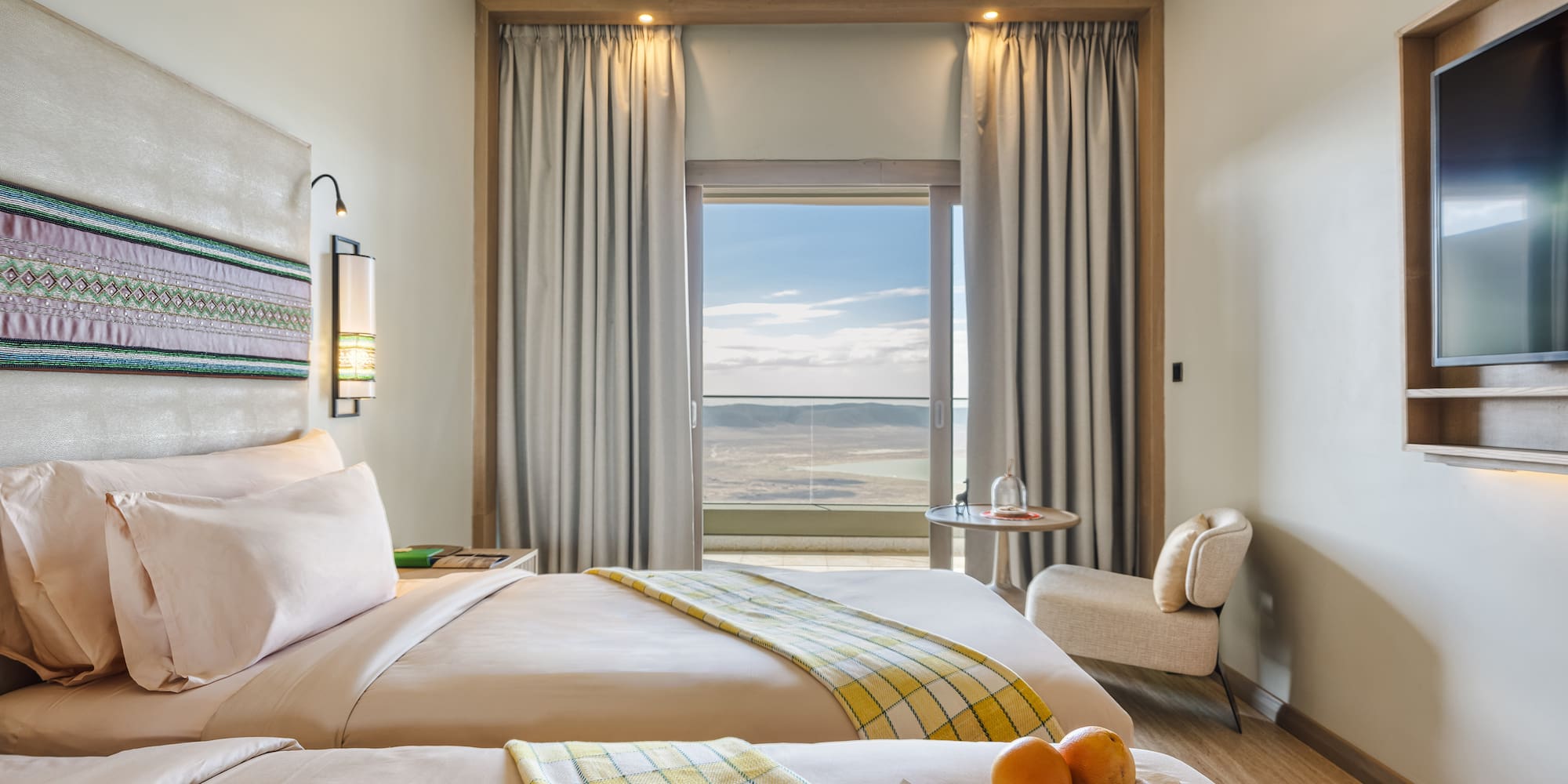 a room with two beds and a table with chairs and a window