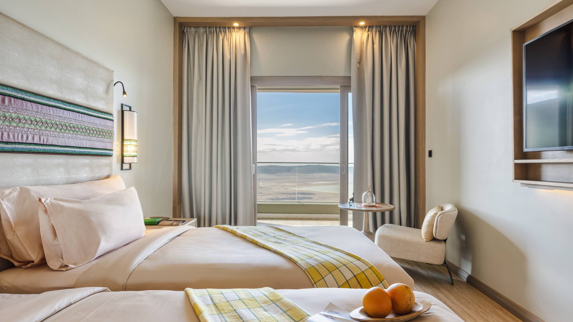 a room with two beds and a table with chairs and a window