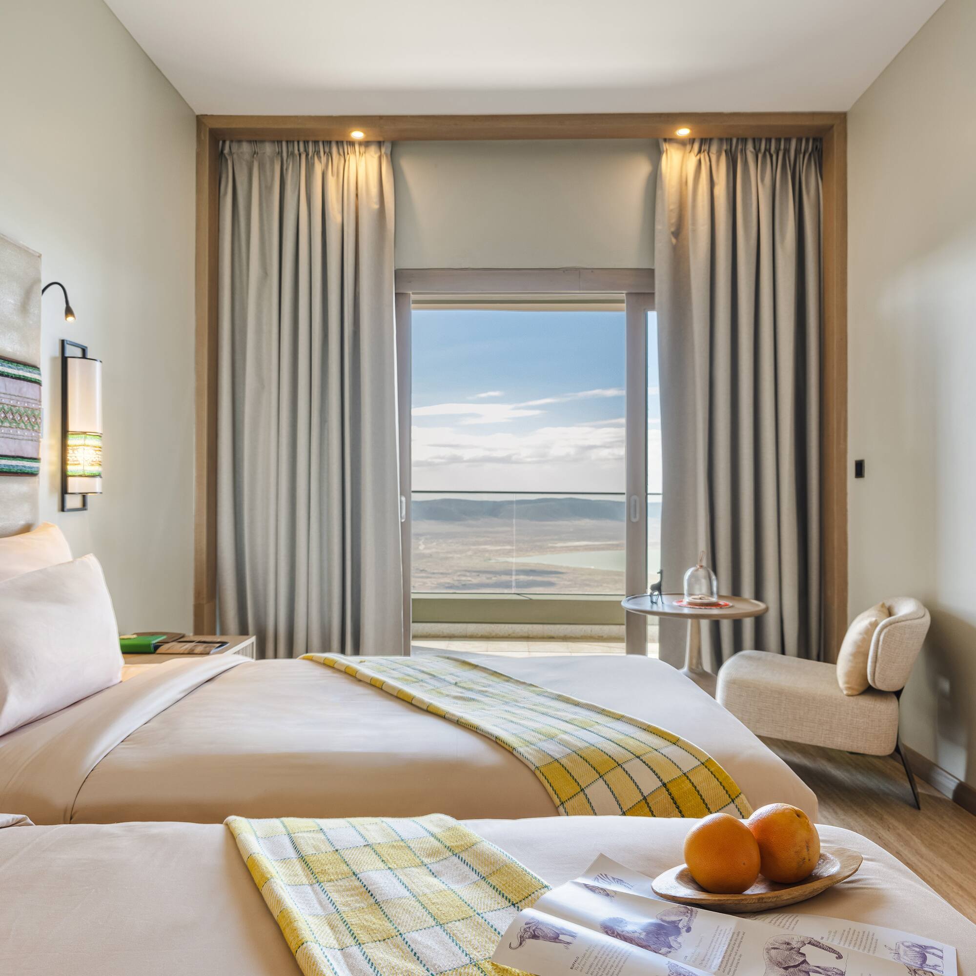 a room with two beds and a table with chairs and a window