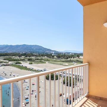 a balcony with a view of a beach and a body of water