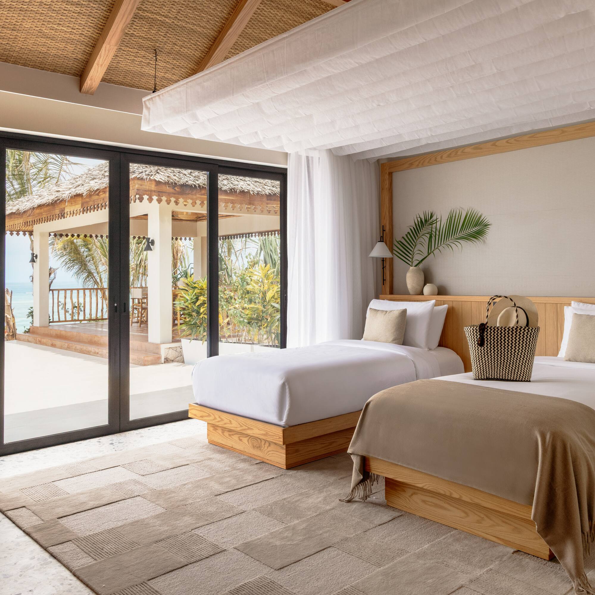 a bedroom with two beds and a glass door