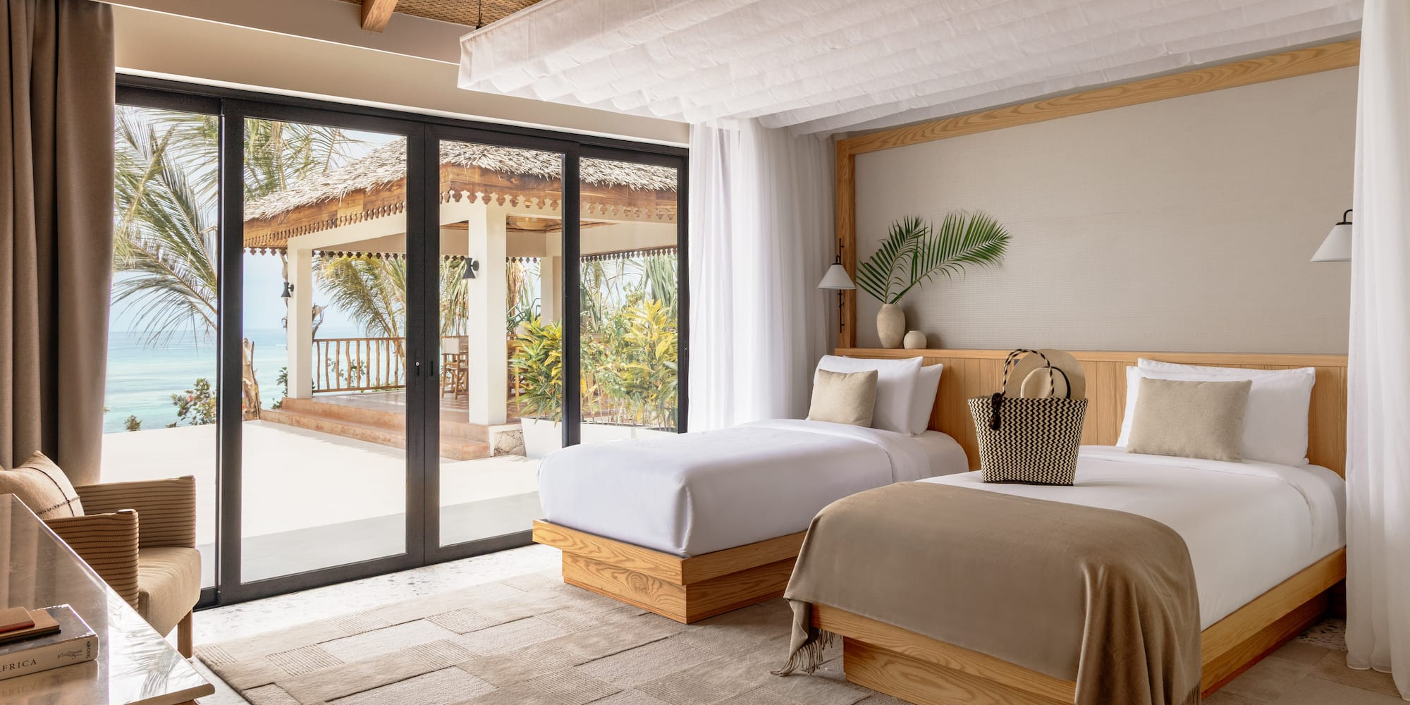 a bedroom with two beds and a glass door