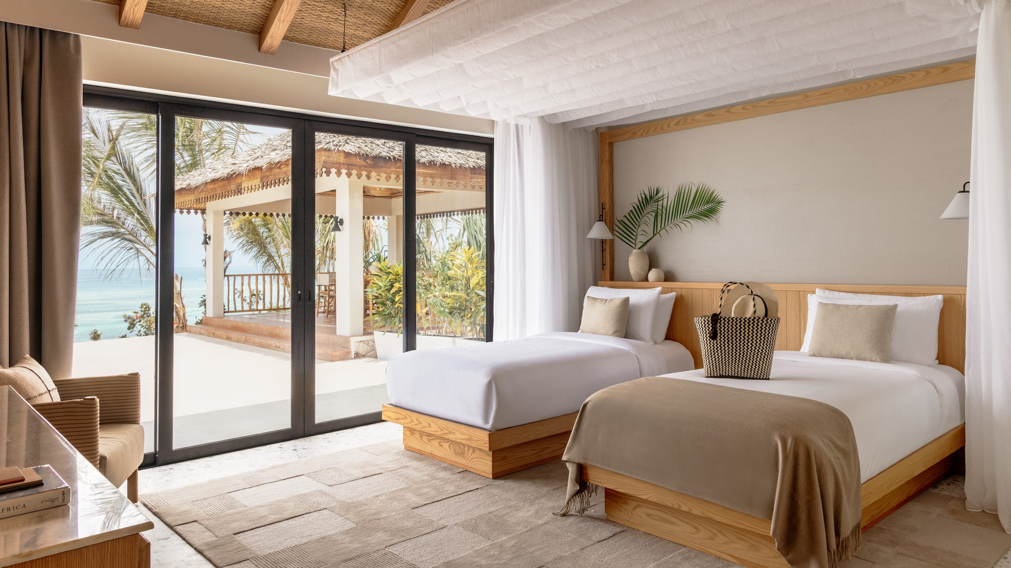 a bedroom with two beds and a glass door