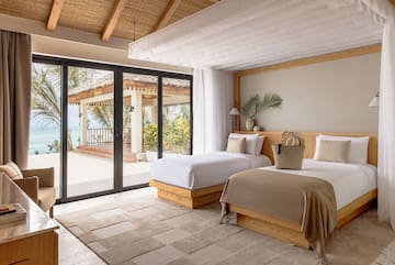 a bedroom with two beds and a glass door