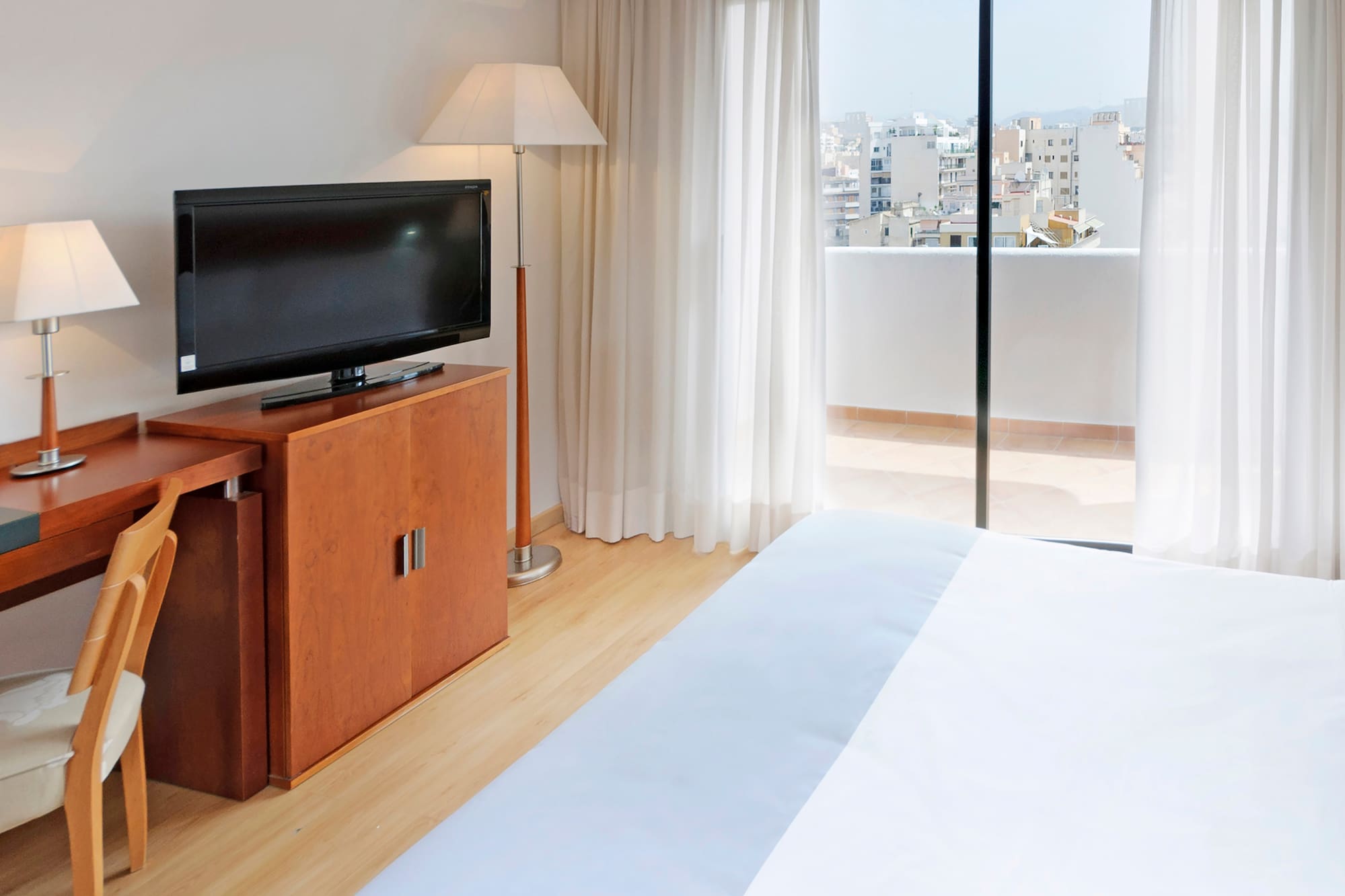 a tv on a stand next to a bed