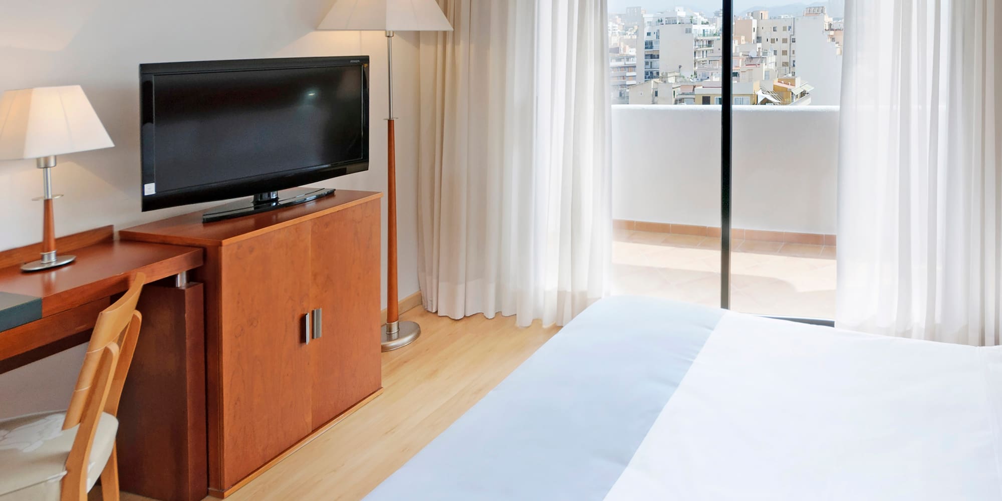 a tv on a stand next to a bed