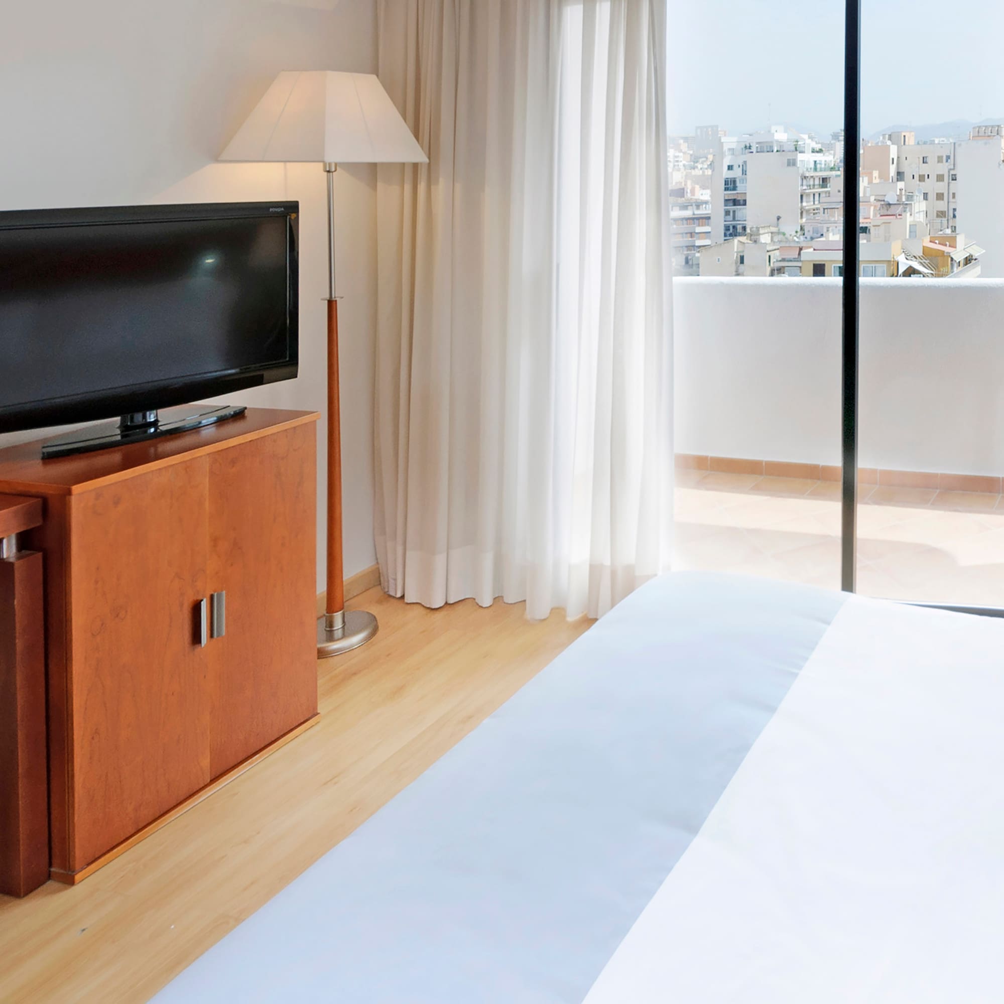 a tv on a stand next to a bed