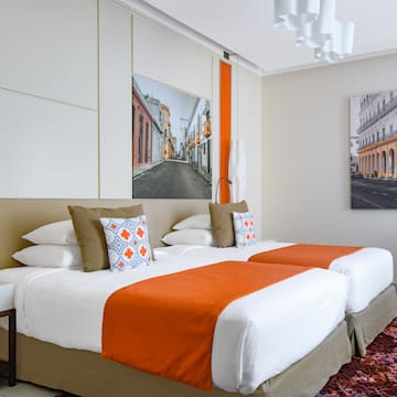 a bed with orange and white pillows