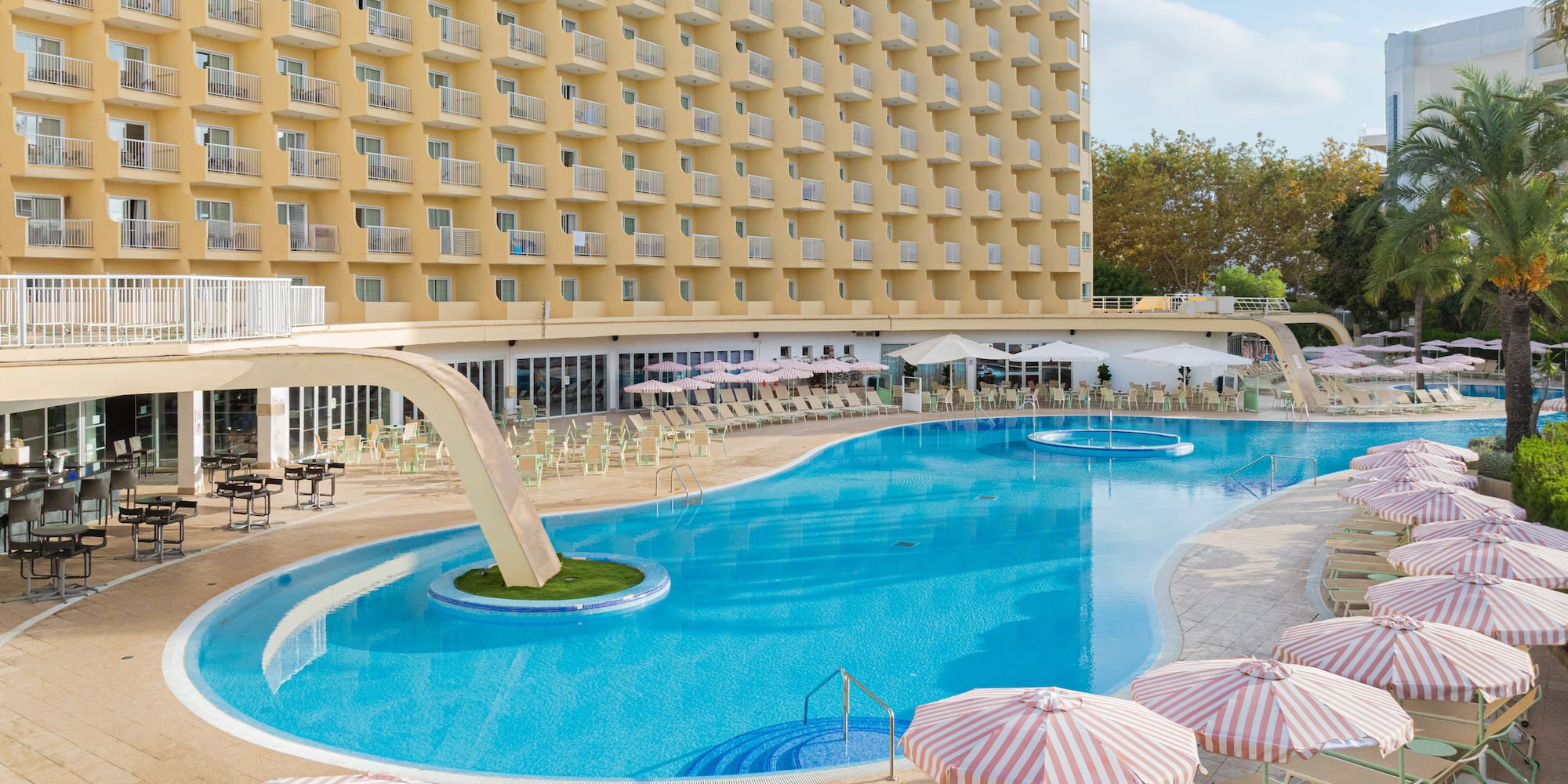 a swimming pool with umbrellas and chairs