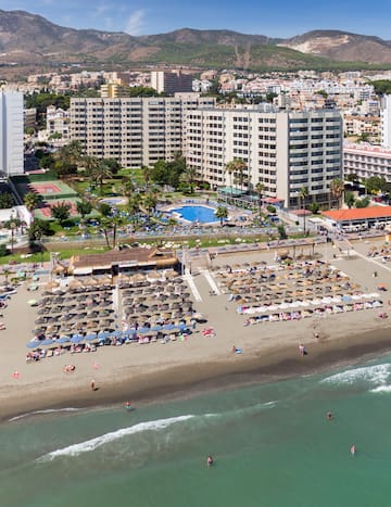 a beach with umbrellas and chairs and a swimming pool